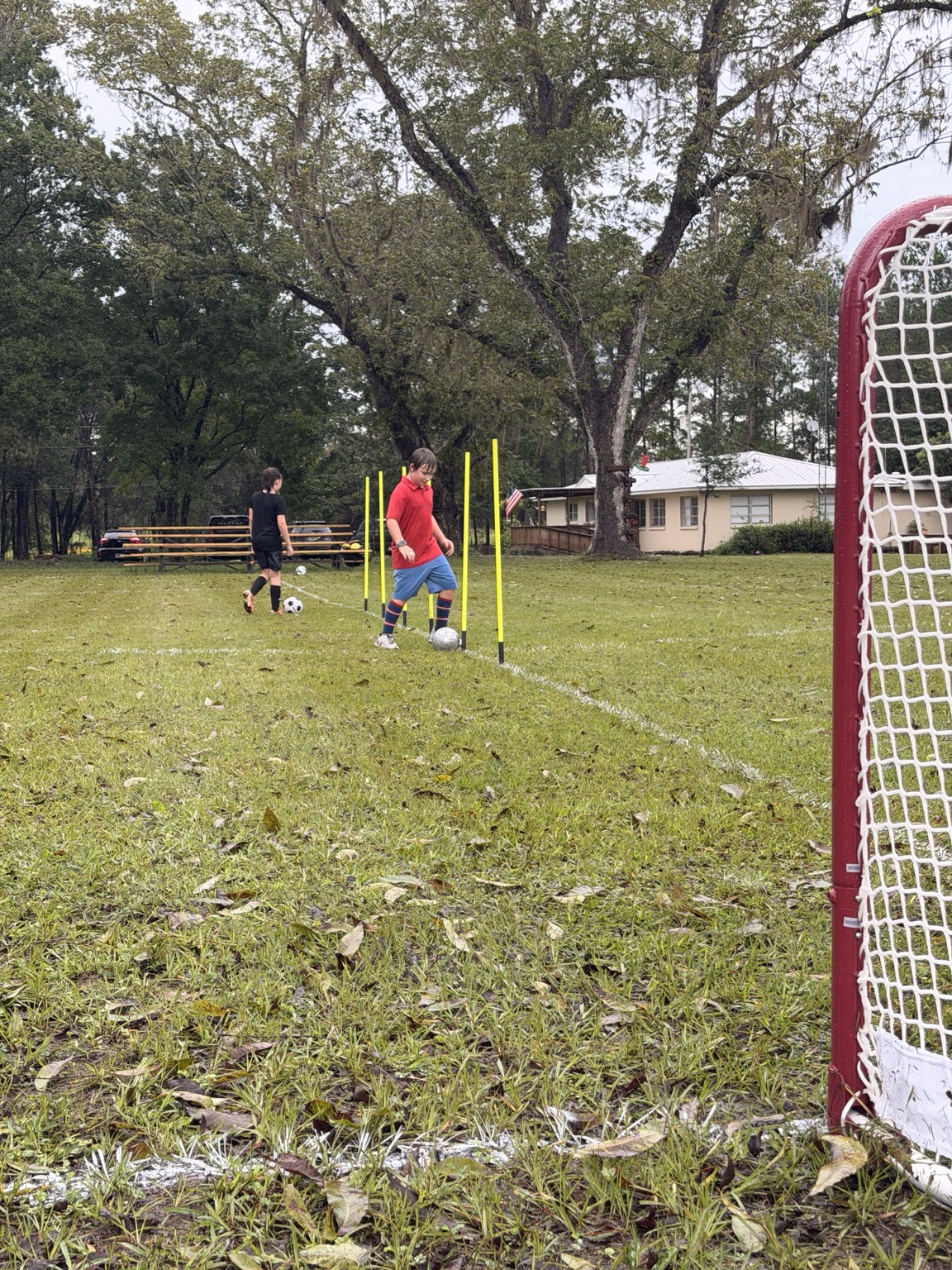 ORVIT students practicing ball control through training poles on the wet field